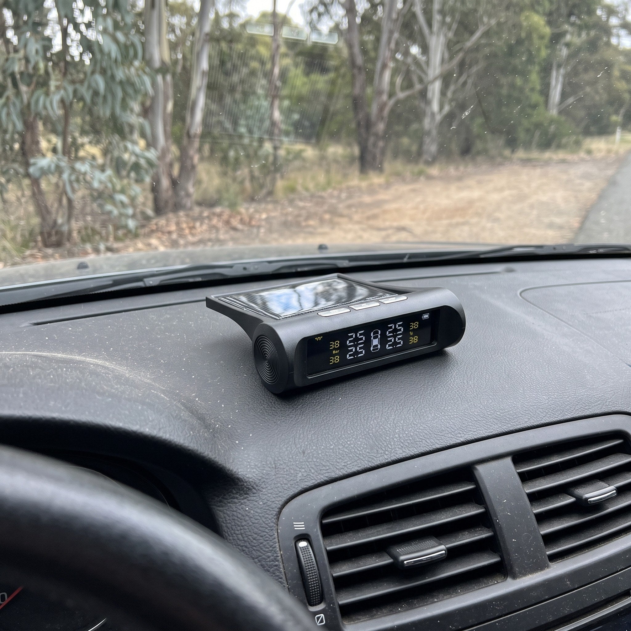 Roadstead monitor on a parked 4WD dashboard by a country road